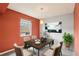 Cozy dining room featuring bright orange walls, a decorative painting, and a window with natural light at 224 Lewfield Cir, Winter Park, FL 32792