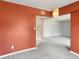 Bright living room with neutral carpet and orange accent wall at 224 Lewfield Cir, Winter Park, FL 32792