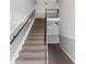 Staircase featuring neutral carpeting, gray walls, and black handrails at 224 Lewfield Cir, Winter Park, FL 32792