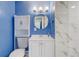 Bathroom with blue walls, white vanity, updated lighting, decorative mirror, and marble tiled shower at 2743 Grandola Dr, Orlando, FL 32811