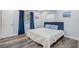 A calming bedroom with a comfortable bed, blue accent pillows, and stylish wooden floors at 2743 Grandola Dr, Orlando, FL 32811