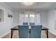 A cozy dining room with a dark wooden table, blue upholstered chairs, and a decorative floral-patterned curtain at 2743 Grandola Dr, Orlando, FL 32811