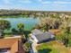 Aerial view of the home on the lake with a lush green lawn and mature trees at 3111 Carmia Dr, Orlando, FL 32806