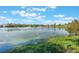 Picturesque view of a lake with lush vegetation and reflections of clouds in the water at 3111 Carmia Dr, Orlando, FL 32806