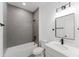 Modern bathroom features a shower over tub, black hardware, and white vanity at 3324 Sw 137Th Loop, Ocala, FL 34473