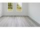 This bedroom has wood-look floors and two windows with outdoor views at 3324 Sw 137Th Loop, Ocala, FL 34473