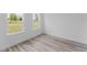 A bright bedroom with wood-look floors and two windows at 3324 Sw 137Th Loop, Ocala, FL 34473