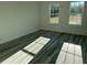 Bedroom featuring modern vinyl floors and natural light streaming through two windows, creating a bright and inviting space at 3324 Sw 137Th Loop, Ocala, FL 34473
