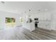 Bright, modern kitchen with white cabinets, an island, stainless appliances, and a sliding glass door at 3324 Sw 137Th Loop, Ocala, FL 34473