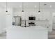 Modern kitchen featuring an island, stainless appliances, white cabinets and counters, and pendant lighting at 3324 Sw 137Th Loop, Ocala, FL 34473