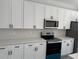 Stylish kitchen featuring white cabinets, stainless steel appliances, and elegant countertops at 3324 Sw 137Th Loop, Ocala, FL 34473