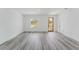 Spacious living room featuring gray flooring, natural light, and a modern wooden door at 3324 Sw 137Th Loop, Ocala, FL 34473