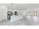 Spacious open-concept kitchen and living room with an island, stainless appliances, and gray wood-look flooring at 3324 Sw 137Th Loop, Ocala, FL 34473