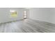 Bright, open room showcasing hard surface flooring, ample natural light, and modern door at 3324 Sw 137Th Loop, Ocala, FL 34473
