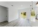 Open-concept living space with sliding glass doors, gray wood-look flooring, and modern pendant lights at 3324 Sw 137Th Loop, Ocala, FL 34473