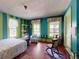 Eclectic bedroom with blue and green striped walls, vintage furniture, and ample natural light. A unique space at 3471 Whitner Way, Sanford, FL 32773