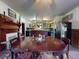 Dining room featuring a large wooden table, colorful rug, and kitchen with yellow shelves in the background at 3471 Whitner Way, Sanford, FL 32773