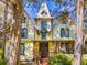 Charming yellow two-story home featuring Queen Anne architecture, a quaint porch, and an American flag at 3471 Whitner Way, Sanford, FL 32773