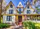 Charming yellow two-story home with Queen Anne architecture, a quaint porch, and an American flag at 3471 Whitner Way, Sanford, FL 32773
