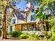 Charming yellow two-story home featuring Queen Anne architecture, a screened porch, and lush landscaping at 3471 Whitner Way, Sanford, FL 32773