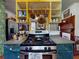 Kitchen with yellow shelving, a gas range, green countertop, and view to fireplace in adjacent room at 3471 Whitner Way, Sanford, FL 32773