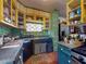 Kitchen with yellow shelving, a sink beneath window, and cabinets with checkerboard curtains at 3471 Whitner Way, Sanford, FL 32773