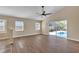 Open living area featuring wood floors, ceiling fan, and sliding glass doors to the screened-in pool at 3814 Aiden Pl, Apopka, FL 32703