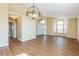 Bright living room featuring wood floors, and an elegant chandelier creating a welcoming and stylish atmosphere at 3814 Aiden Pl, Apopka, FL 32703