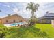 Backyard pool area surrounded by palm trees, lush plants and manicured landscape at 3814 Aiden Pl, Apopka, FL 32703