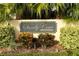 Sandy Cove Condominiums sign surrounded by palm trees and manicured landscaping creating an inviting entrance at 626 Orange Dr # 242, Altamonte Springs, FL 32701