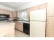 Eat-in kitchen with tan cabinets, black appliances, tile flooring, and a garden window at 626 Orange Dr # 242, Altamonte Springs, FL 32701