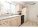 Well-lit kitchen with tan cabinets, black appliances, and a large window over the sink at 626 Orange Dr # 242, Altamonte Springs, FL 32701