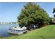 Tranquil lakefront setting featuring a boat, lush trees, and serene views at 626 Orange Dr # 242, Altamonte Springs, FL 32701