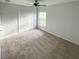 Neutral bedroom with carpeting, window, ceiling fan, and double-door closet at 734 Fraser Ct, Kissimmee, FL 34759