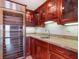 This bar features custom cabinetry with glass doors, granite countertops, and a wine refrigerator at 7550 Hinson St # 11C, Orlando, FL 32819