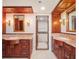 Elegant bathroom featuring wood cabinets, granite countertops, decorative mirrors, and a walk-in closet at 7550 Hinson St # 11C, Orlando, FL 32819