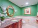 Bathroom with marble countertop, green walls, gold mirror and cabinet at 7550 Hinson St # 11C, Orlando, FL 32819