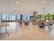 Large common area with tables, chairs, and floor to ceiling windows offering lake views at 7550 Hinson St # 11C, Orlando, FL 32819