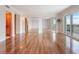 Spacious living room area featuring hardwood floors, sliding glass doors to a balcony, and large mirrored closets at 7550 Hinson St # 11C, Orlando, FL 32819