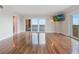 A bright living room featuring hardwood floors, a flat-screen TV, and sliding glass doors to a balcony with scenic views at 7550 Hinson St # 11C, Orlando, FL 32819