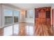 Hardwood living room featuring balcony access, an accent wall, and lots of natural light at 7550 Hinson St # 11C, Orlando, FL 32819