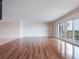 Large living room area featuring hardwood floors and sliding glass doors to an outside balcony at 7550 Hinson St # 11C, Orlando, FL 32819