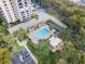 Aerial close up of the pool area, showing a well kept pool, landscaping, and parking area at 7550 Hinson St # 11C, Orlando, FL 32819