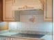 Kitchen featuring ornate hood and backsplash above the stove top at 7550 Hinson St # 11C, Orlando, FL 32819