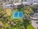 Aerial view of the property's blue tennis courts, surrounded by lush green trees at 7550 Hinson St # 11C, Orlando, FL 32819