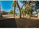 Spacious backyard with mature trees and a white privacy fence at 8322 Lake Lucy Dr, Orlando, FL 32818
