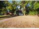 View of the home from the side yard surrounded by mature landscaping at 8322 Lake Lucy Dr, Orlando, FL 32818