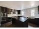 Modern kitchen with stainless steel appliances, a center island, and white countertops with dark wood cabinets at 8322 Lake Lucy Dr, Orlando, FL 32818