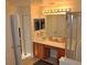 Bathroom featuring a double sink vanity with cabinets, large mirror, and a glass shower at 913 Henley Cir, Davenport, FL 33896