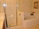 Bright bathroom featuring a tiled shower with glass door and a large soaking tub at 913 Henley Cir, Davenport, FL 33896